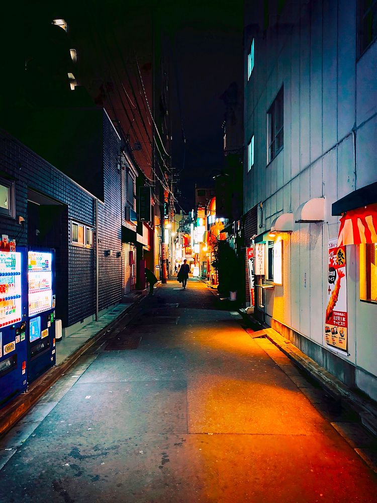 Man Walking Down a Dark Backstreet, Tokyo, JapanA lone man walks down a dark back alley lined with drink vending machines…