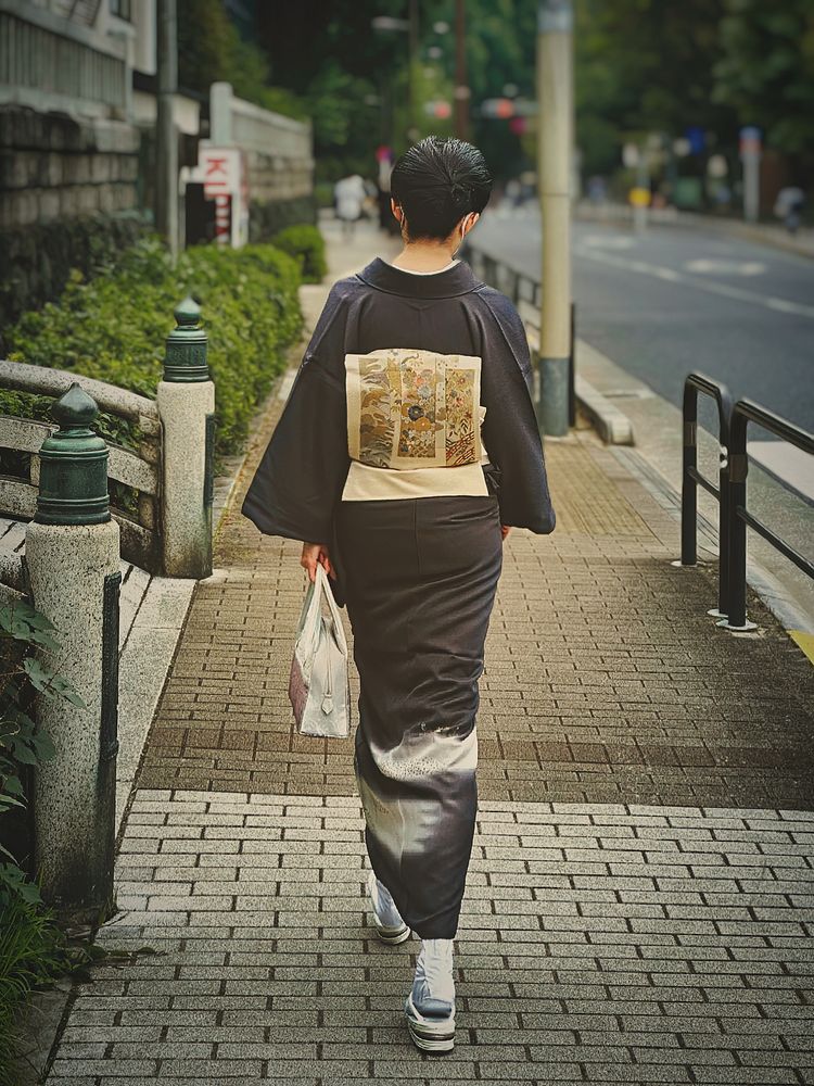 Woman Wearing Kimono, Tokyo, JapanA Japanese woman wearing a traditional garment (kimono) walking on a sidewalk near Ueno…