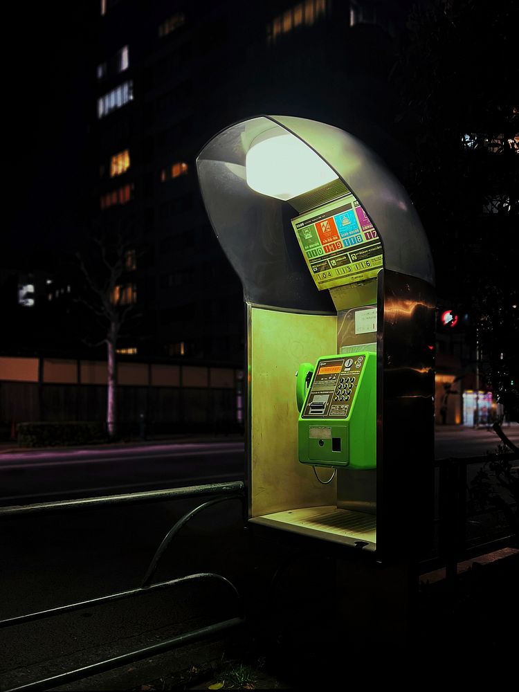 Public Telephone at Night, Tokyo, JapanA roadside green public telephone illuminated Ikenohata, Taito City, Tokyo, Japan, on…