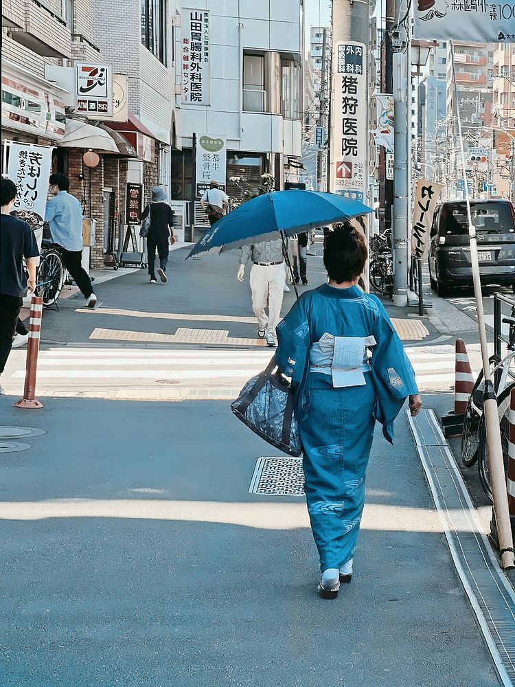 Woman Wearing Kimono, Tokyo, JapanA woman wearing an electric blue kimono and carrying a sun parasol, walking in Nezu…