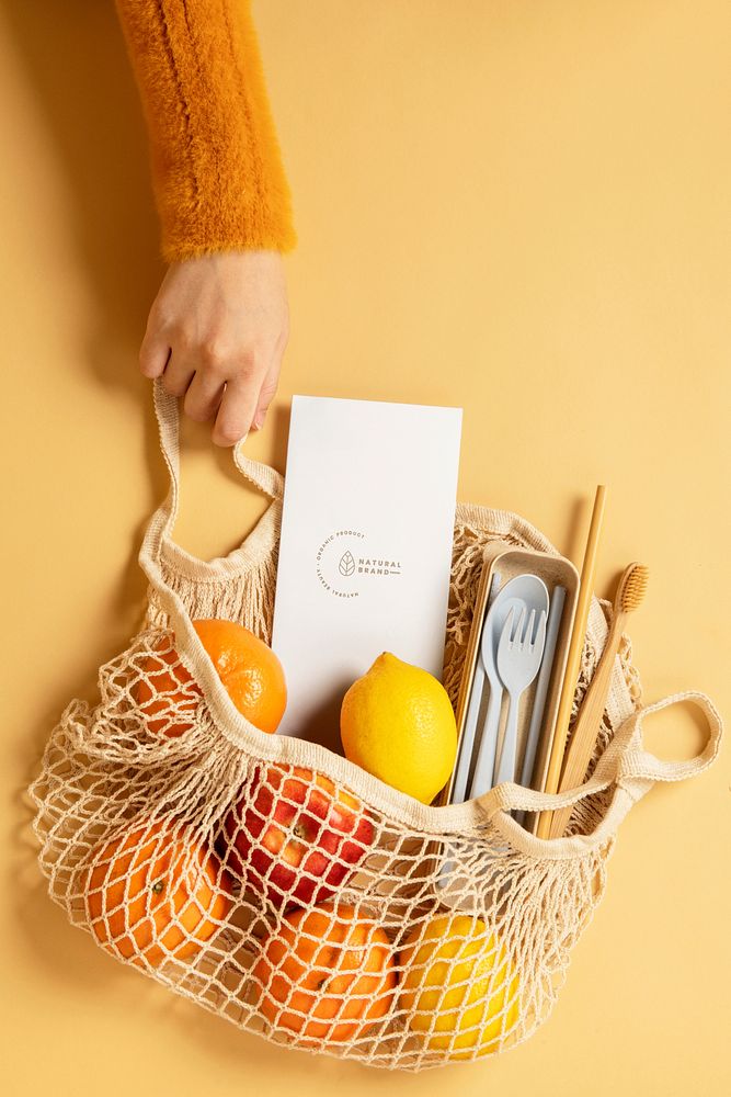 Reusable net bag full with fruits and eco-friendly travel utensils