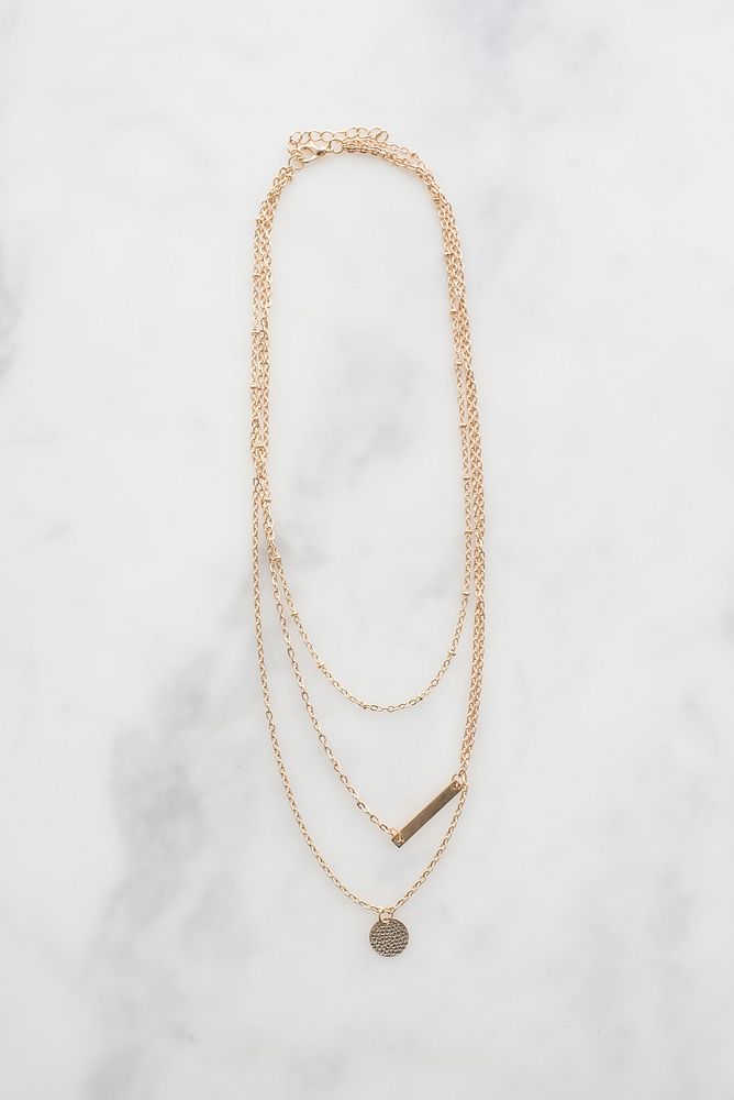 Dainty gold necklace with two pendants.