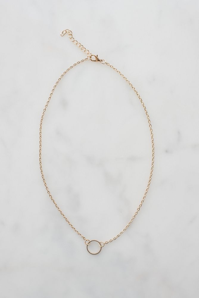 Gold chain with circle pendant in middle.