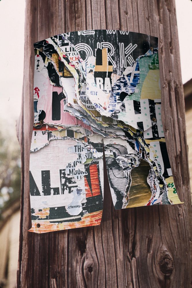 Torn poster on wooden pole