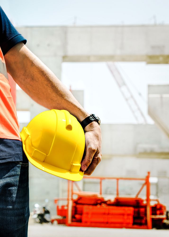 Man holding safety helmet, construction PPE