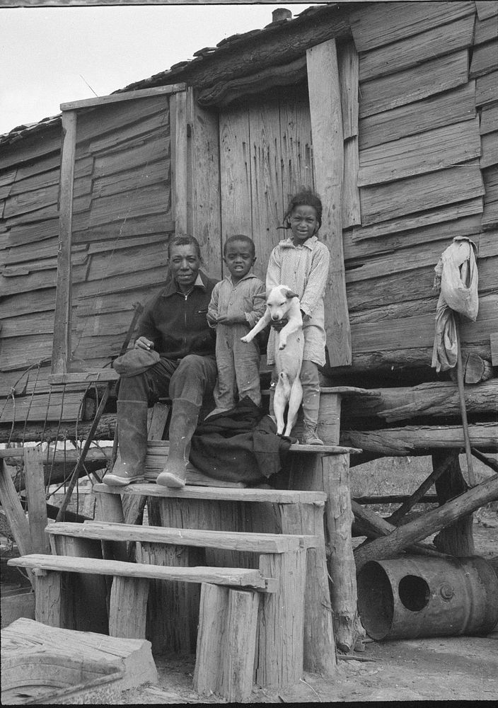 A.J. Hunter, first  labor homes occupant, and two of his three children on front steps of shack he vacated. Southeast…