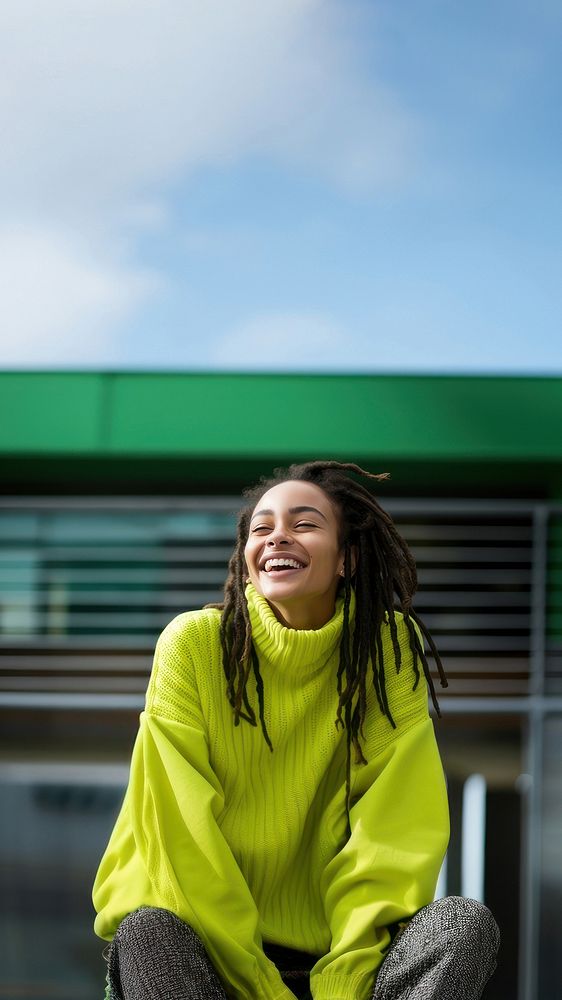 a woman with dreadlocks smiling wearing lime green sweater, playful poses, close up, outdoor city, cool. AI generated Image…