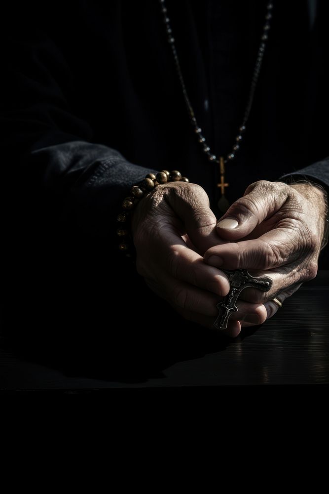 Hands holding a cross hand jewelry finger. 