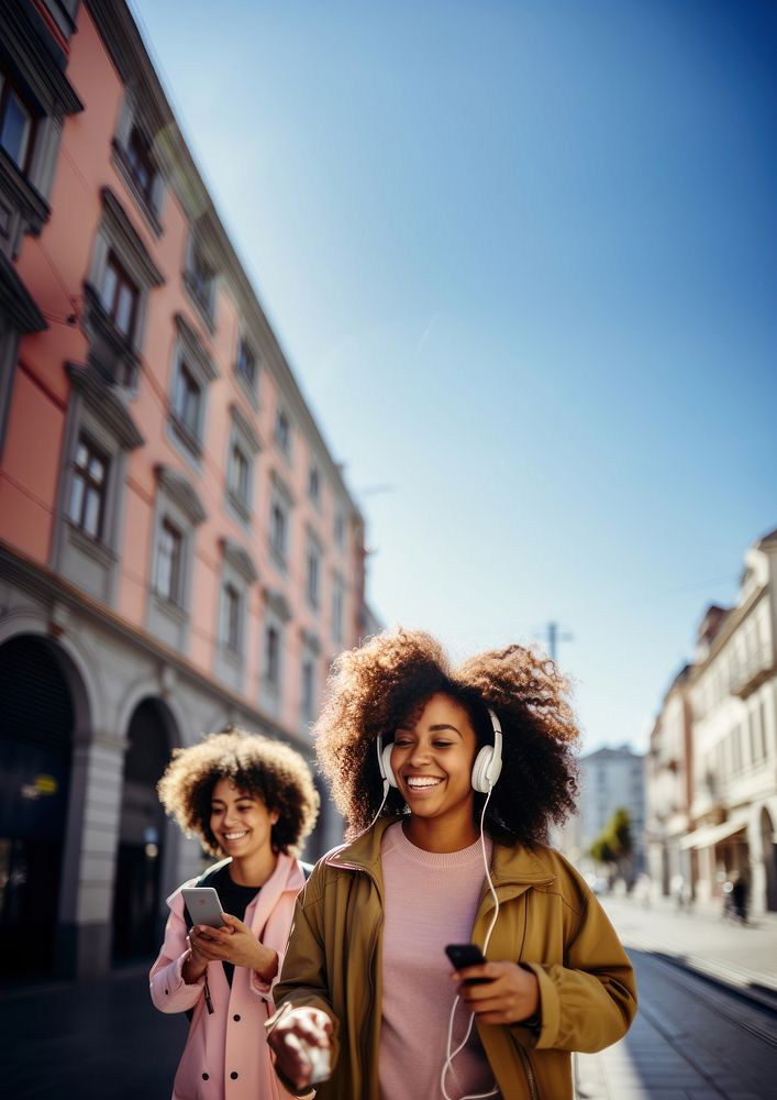 Two female black friends walking adult phone city. 