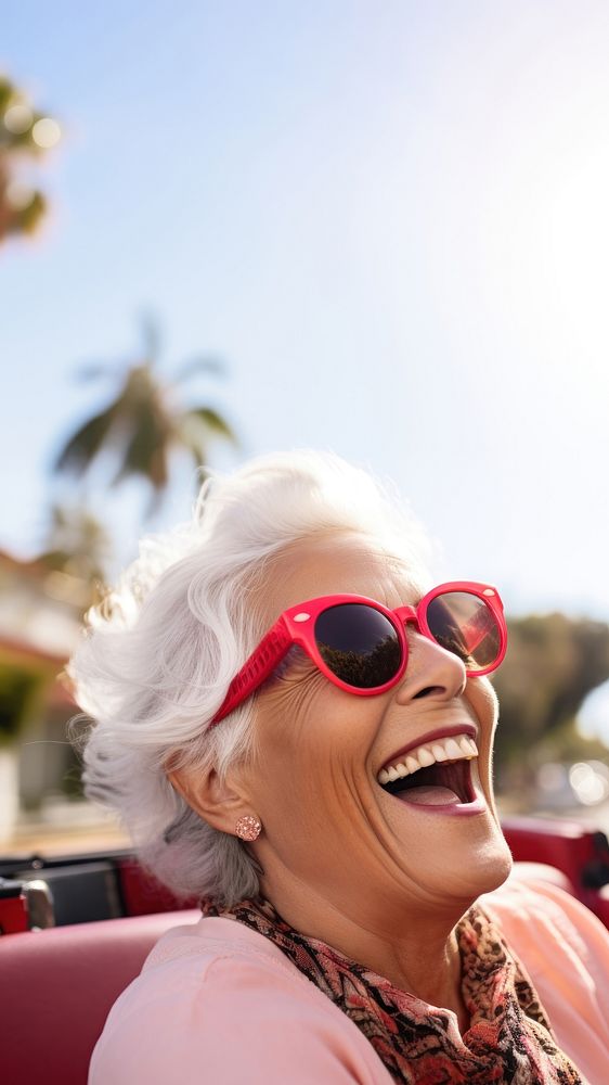 Eldery woman driving sunglasses laughing portrait. 