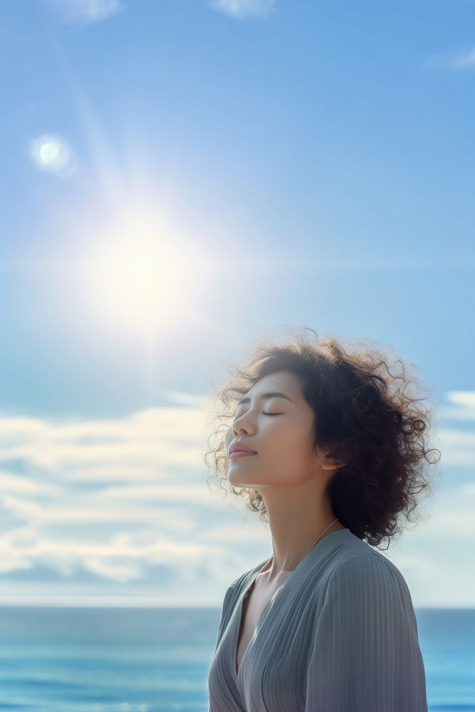 photo of woman praying with bluesky on the sea with blurred vision. AI generated Image by rawpixel. 