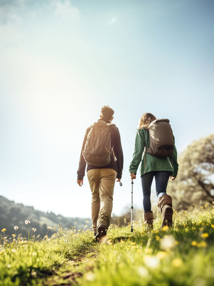 photo of hiking couple set off across hillside meadow. 