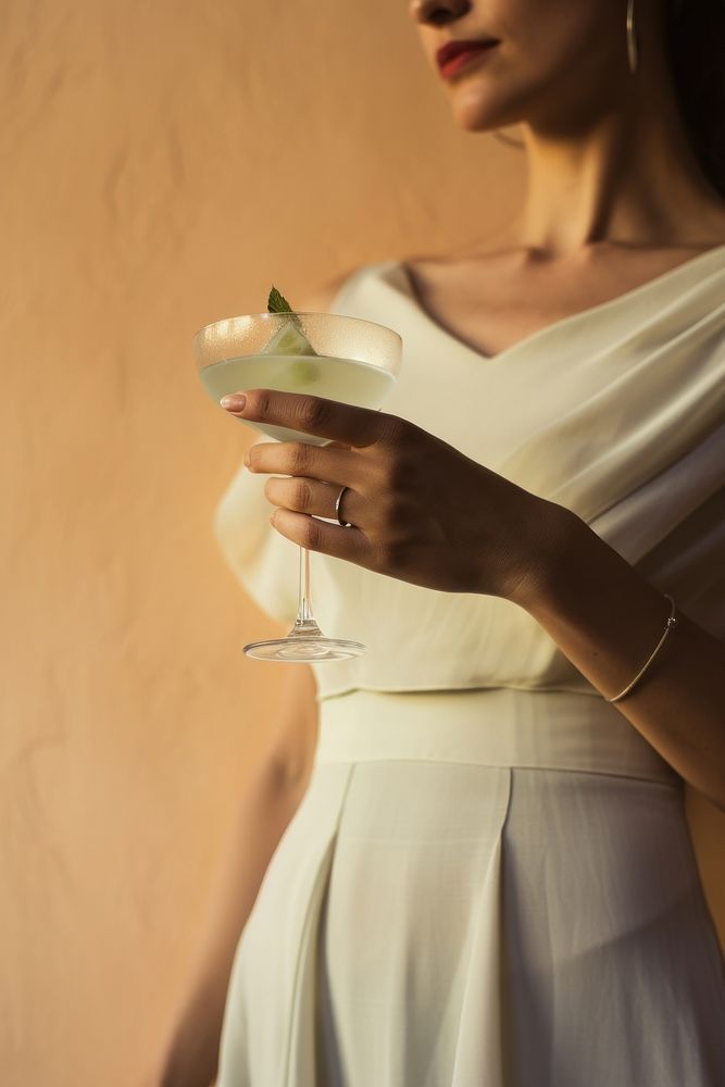 Woman hand holding cocktail fashion wedding finger. 