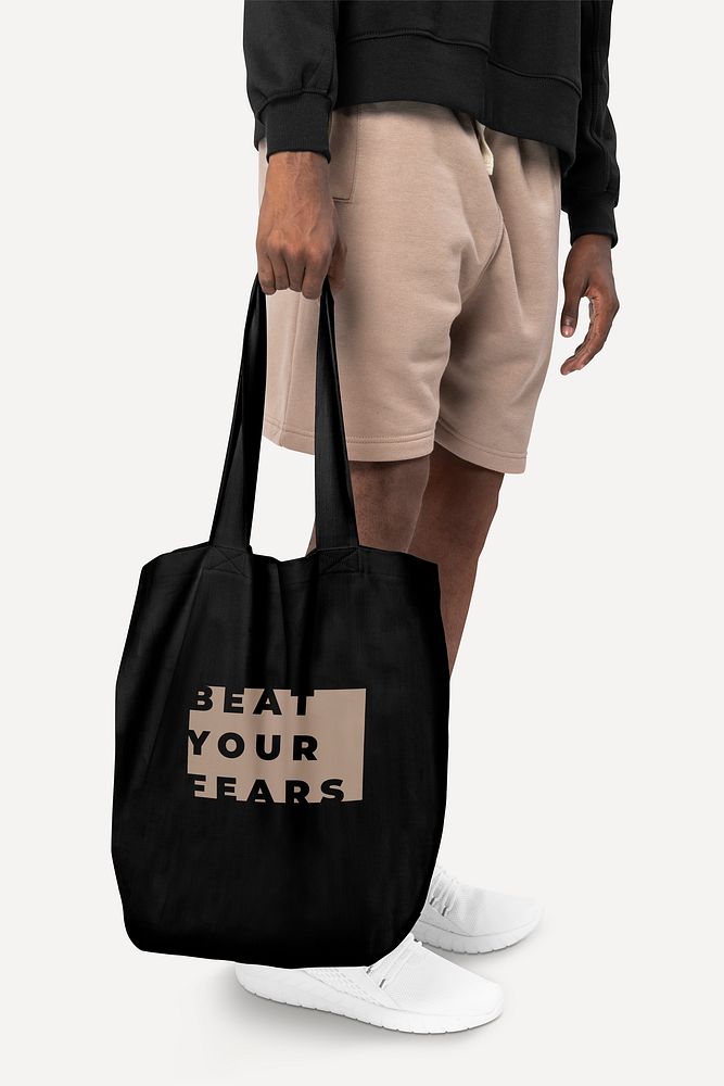 Black tote bag psd mockup with beat your fears typography accessory studio shoot