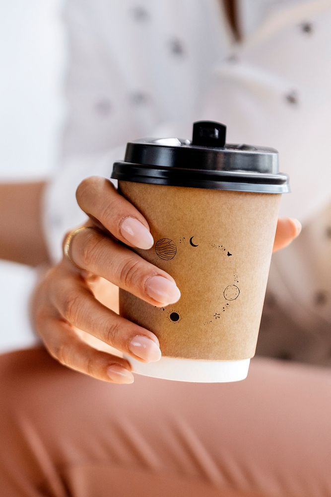 Woman holding a takeaway paper coffee cup mockup