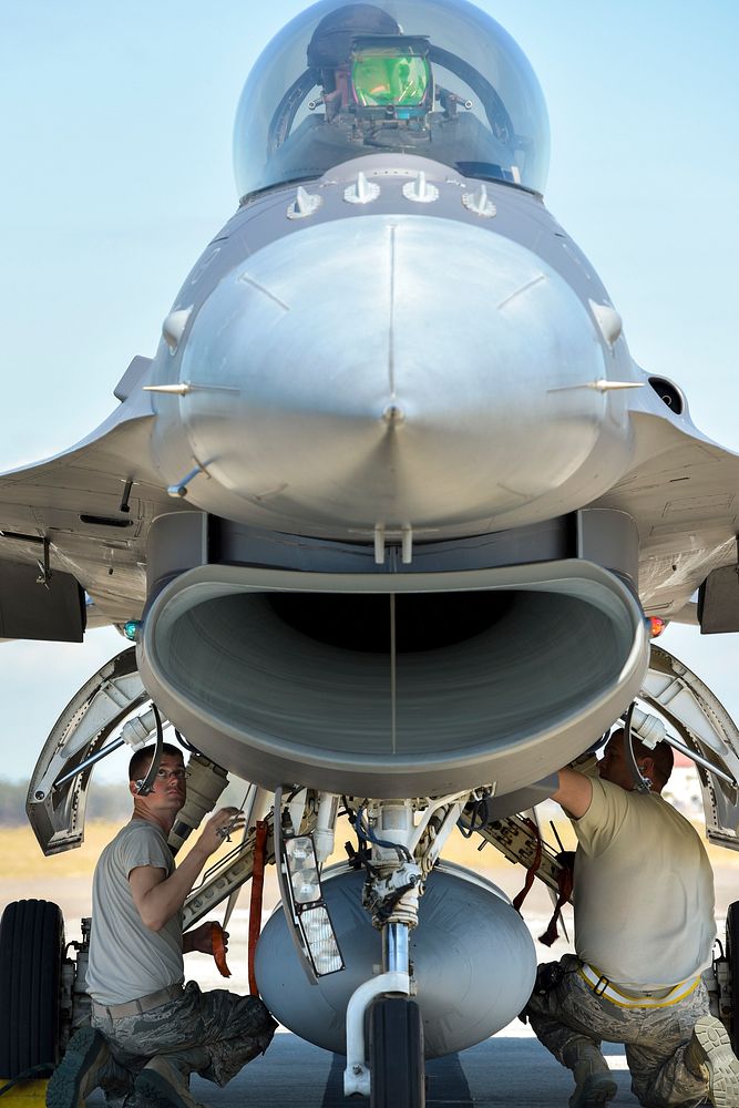 F-16 crew chiefs assigned to the 180th Fighter Wing, Ohio Air National Guard, inspect the hydraulic landing gear systems of…