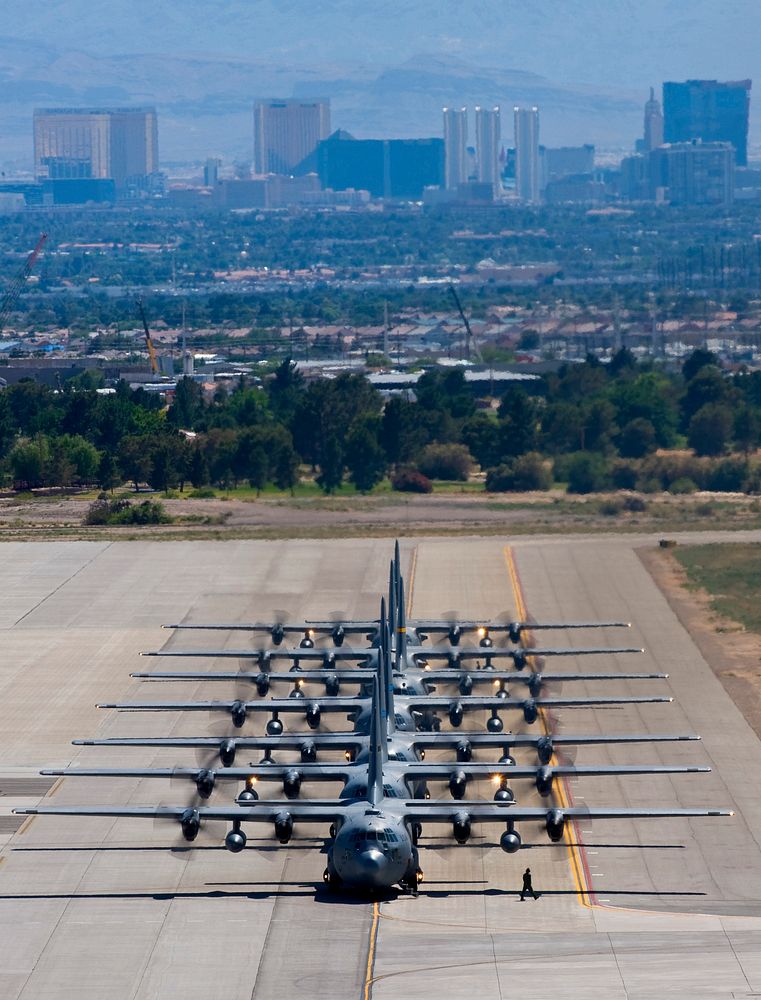 A line of C-130 Hercules aircraft taxis during the U.S. Air Force Weapons School Mobility Air Forces Exercise on Nellis Air…