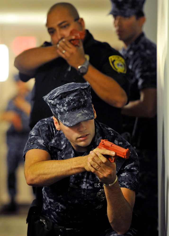 U.S. Navy Master-at-Arms Seaman Jon Finley and his team post outside a door at the Pacific Beacon housing complex at Naval…