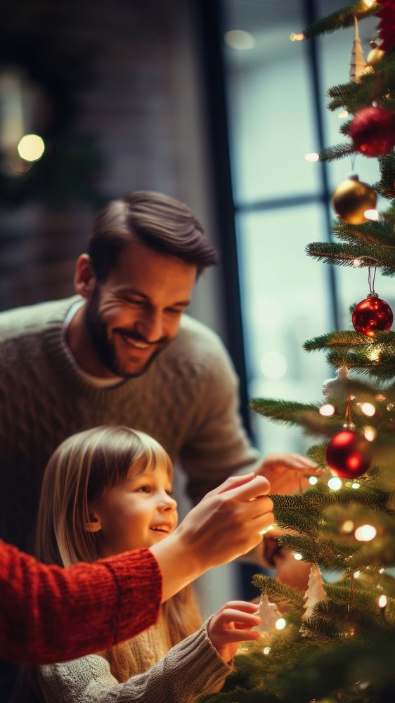 closeup photo of family decorating a Christmas tree.  