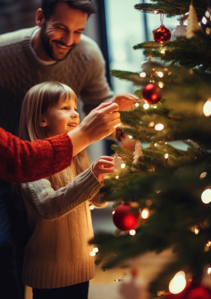 closeup photo of family decorating a Christmas tree.  