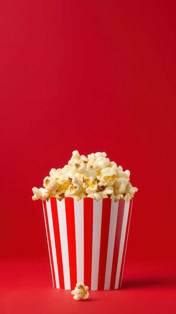 a photograph of a striped box with popcorn isolated on solid color background.  