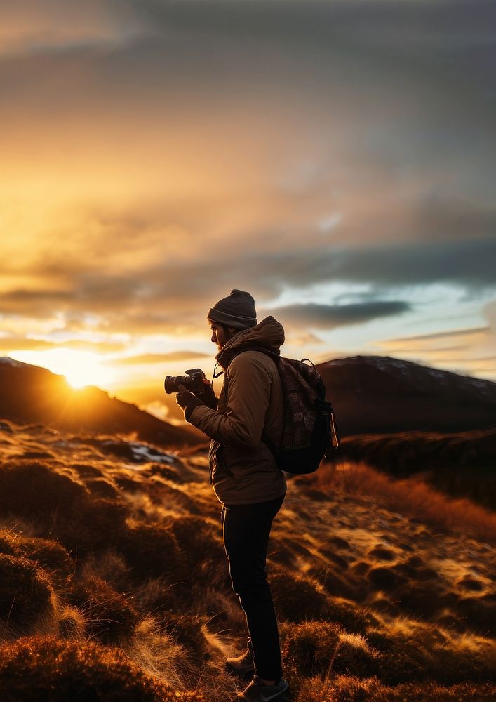 front-left view Photo of a man holding camera, taking picture in the wild in a chilly day. 