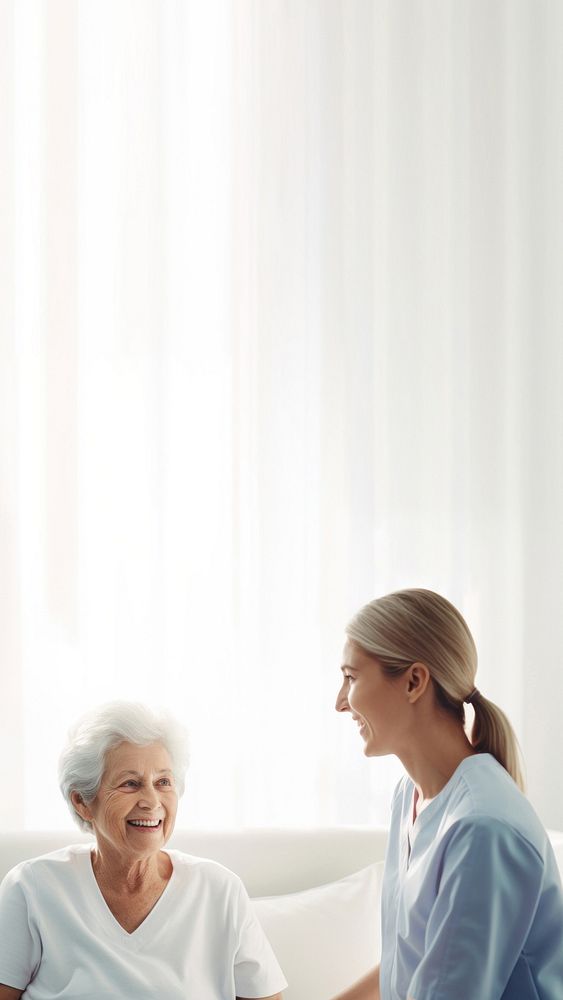 minimal, photo of staff caregiver talking to senior woman in hospital. 