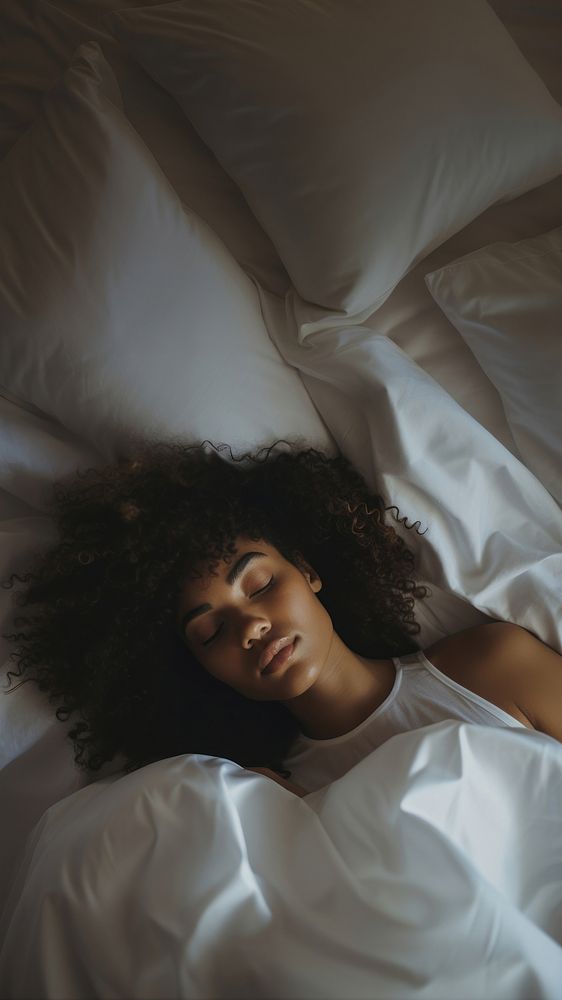 photos of a black woman lying on the side sleeping in white bed. 