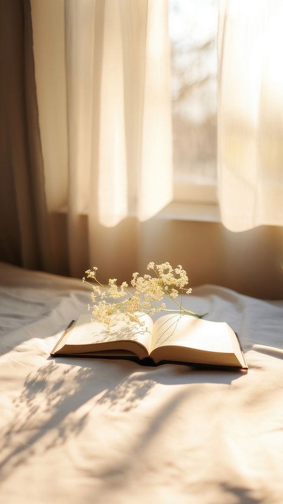 minimal photo of an open book sitting on top of a white sheet.  
