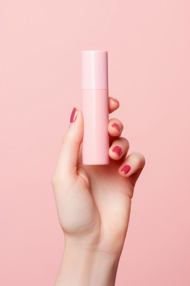Hand holding lipstick cosmetics pink pink background. AI generated Image by rawpixel.