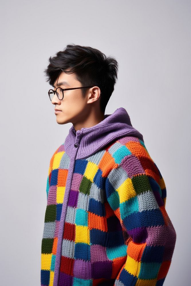 Wearing colorful sweater glasses white background sweatshirt. 