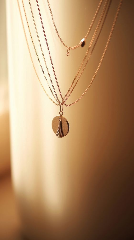 Elegant gold necklaces with delicate chains and a round pendant. The gold pendant and chains create a stylish, sophisticated…