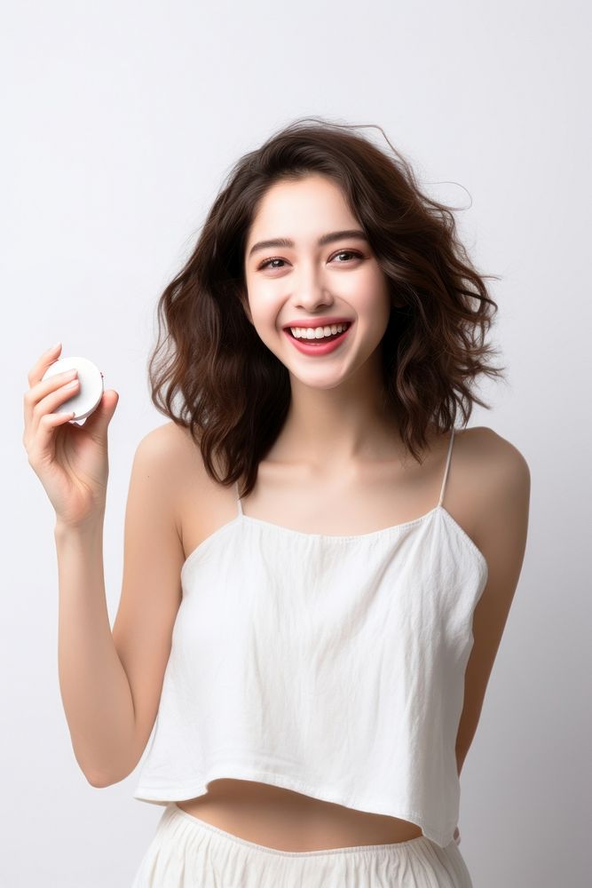 A Young woman holding cosmetic portrait adult smile. AI generated Image by rawpixel.
