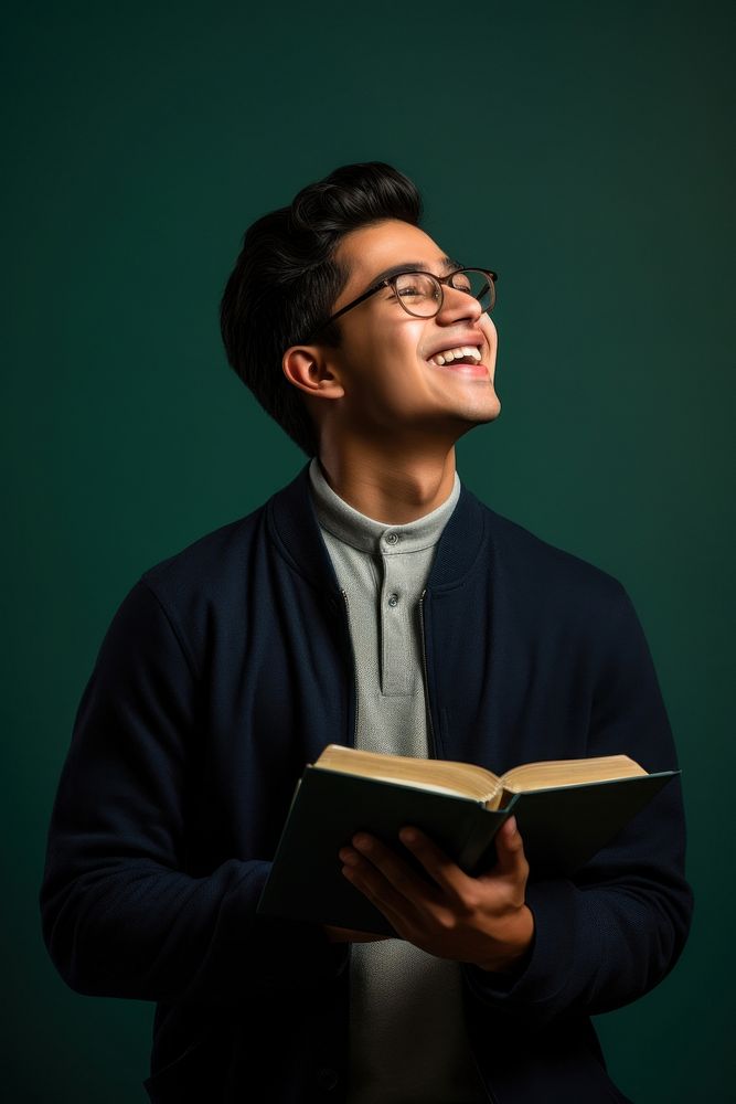 South asian student holding a book publication looking reading. AI generated Image by rawpixel.