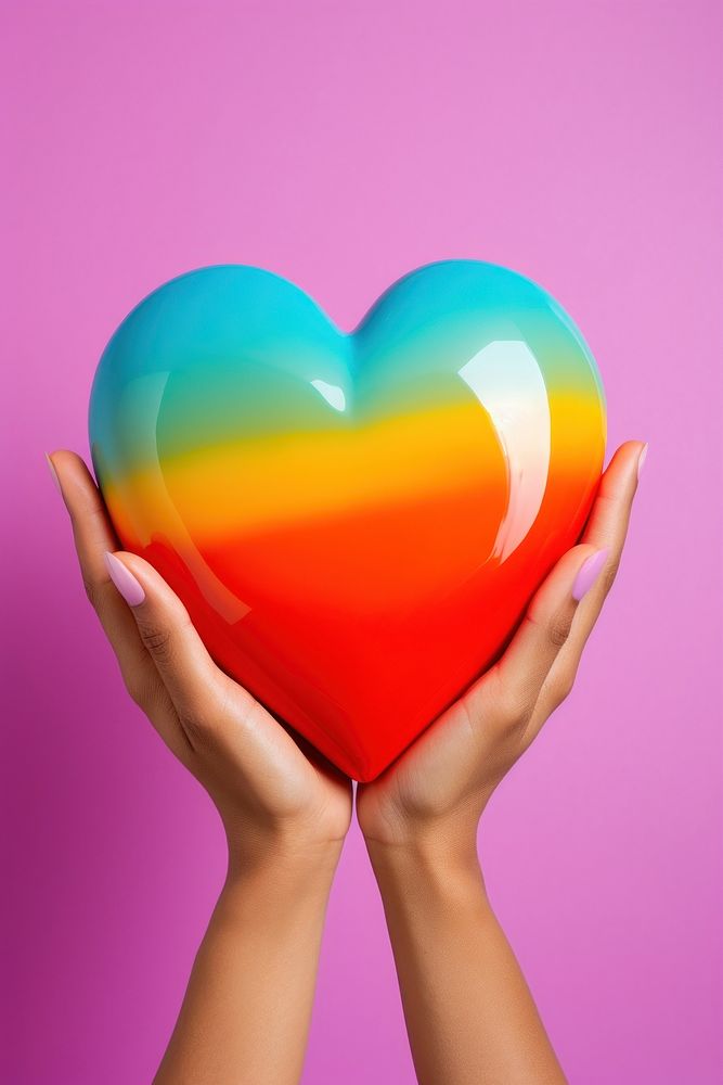 Hand holding big ceramic rainbow heart basketball romance balloon. AI generated Image by rawpixel.