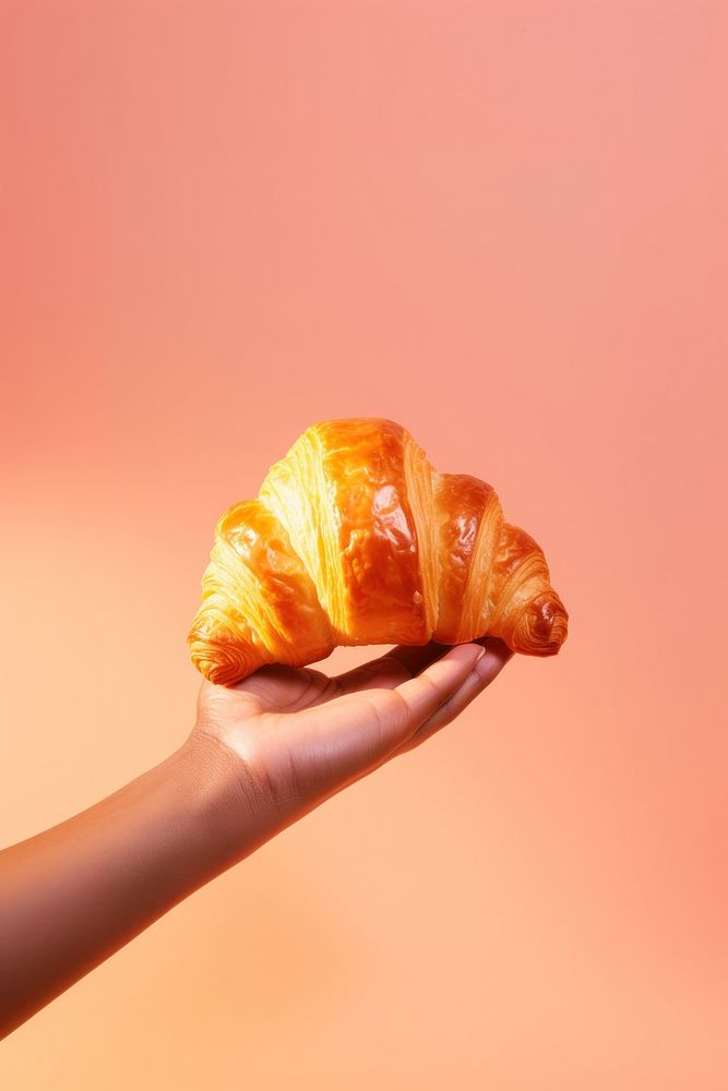 Hand holding a croissant food viennoiserie freshness. AI generated Image by rawpixel.