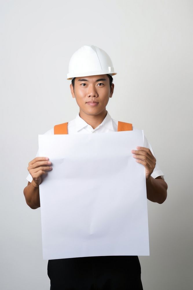 A asian construction worker in uniform man portrait holding hardhat. AI generated Image by rawpixel.
