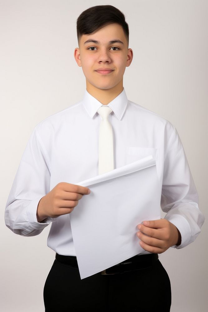A student weraing uniform boy portrait holding shirt. AI generated Image by rawpixel.