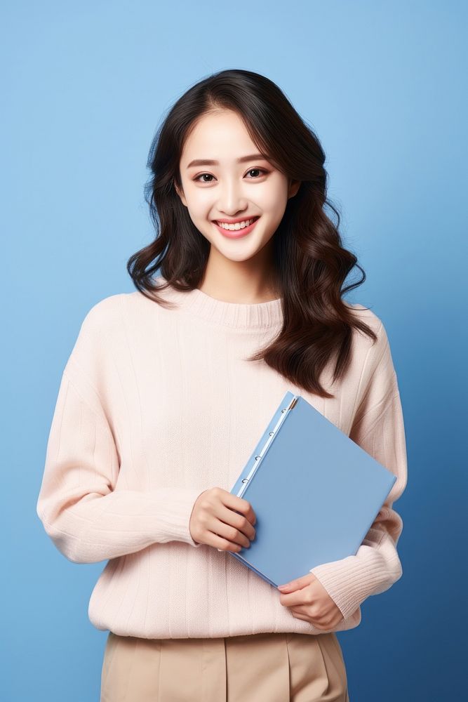 A smile student woman holding book portrait adult technology. AI generated Image by rawpixel.