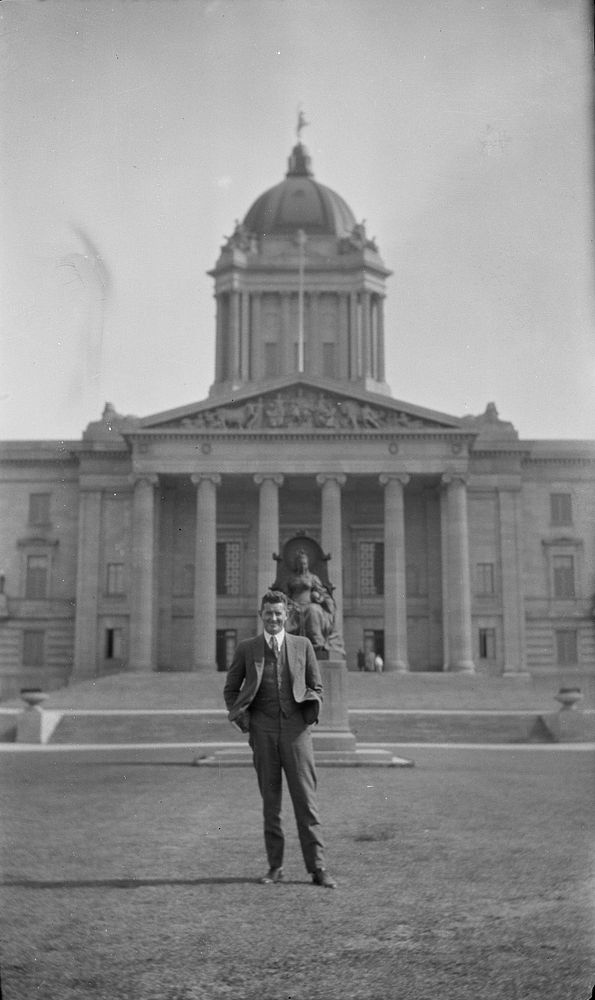 Man standing in front of Manitoba Legislative Building, Winnipeg (1920s to 1930s) by Roland Searle.
