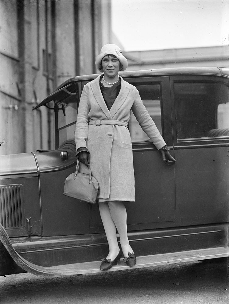 Woman standing on car running board by Leslie Adkin.