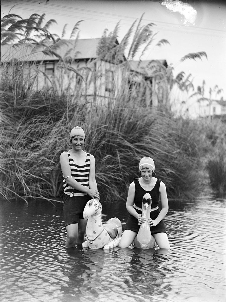 Two women in pond with inflatable toys by Leslie Adkin.