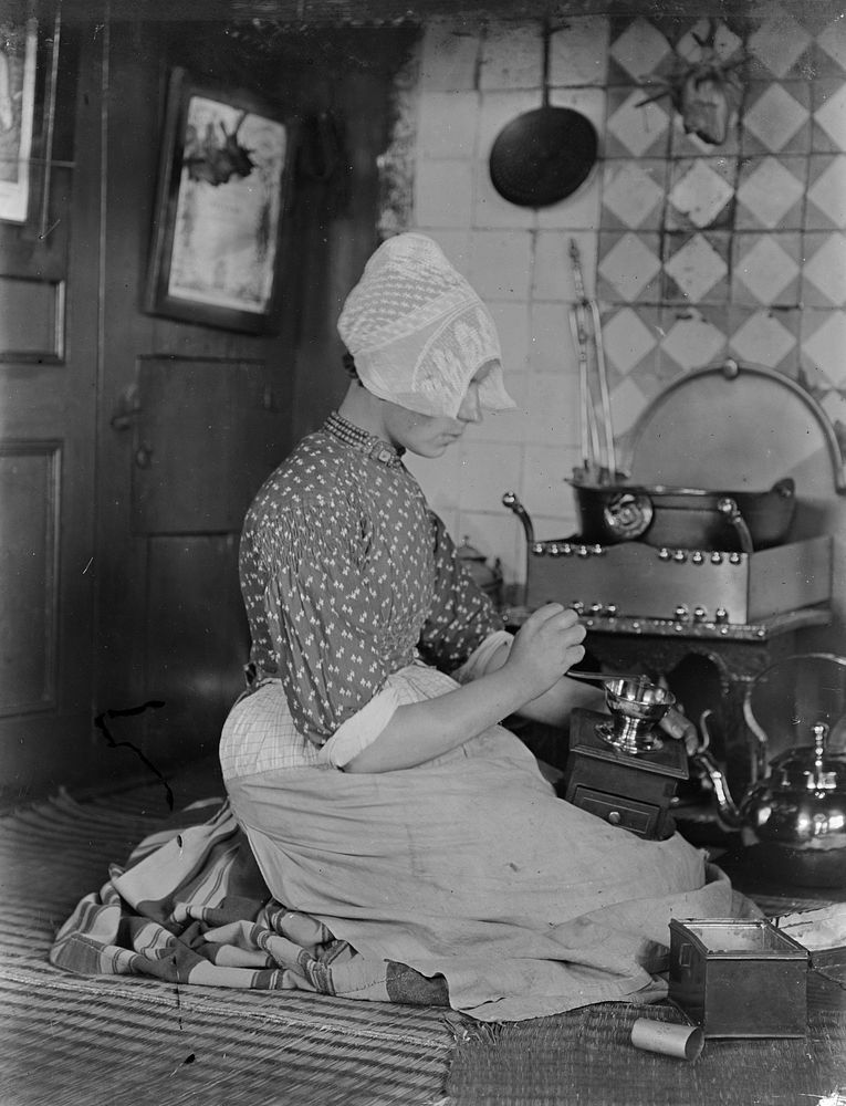 Young woman using a grinder, the Netherlands (1906-1917) by George Crombie.