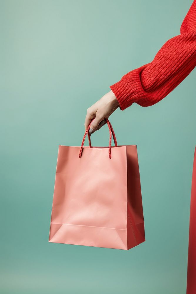 Hand holding shopping bags handbag consumerism accessories. AI generated Image by rawpixel.