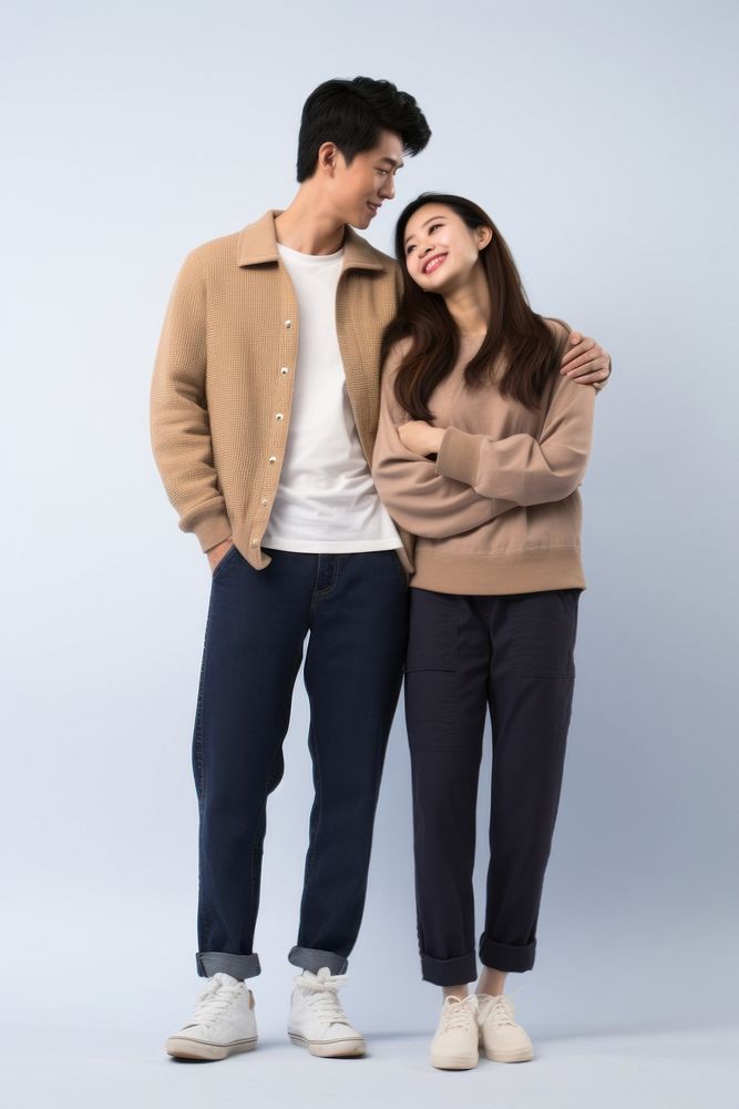 A young asian couple hugging and looking at the camera standing sweater adult. AI generated Image by rawpixel.