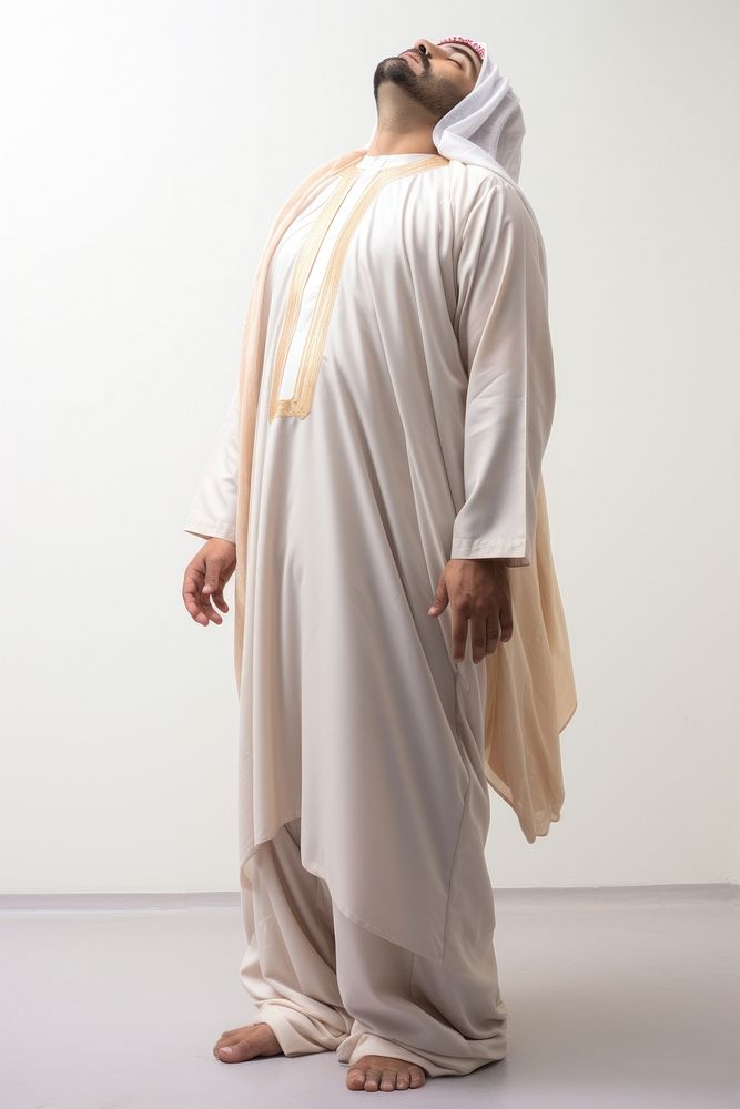 An Arab man standing with his head tilted up while looking at the sky fashion adult robe. AI generated Image by rawpixel.