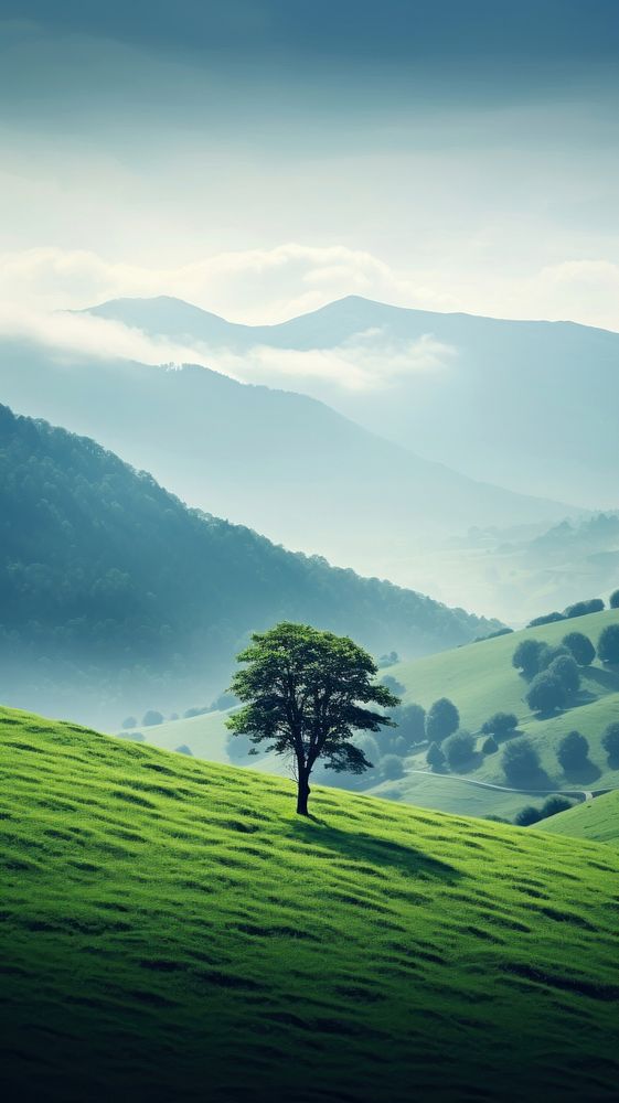 Tree in the middle of a mountain meadow nature tree landscape. AI generated Image by rawpixel.