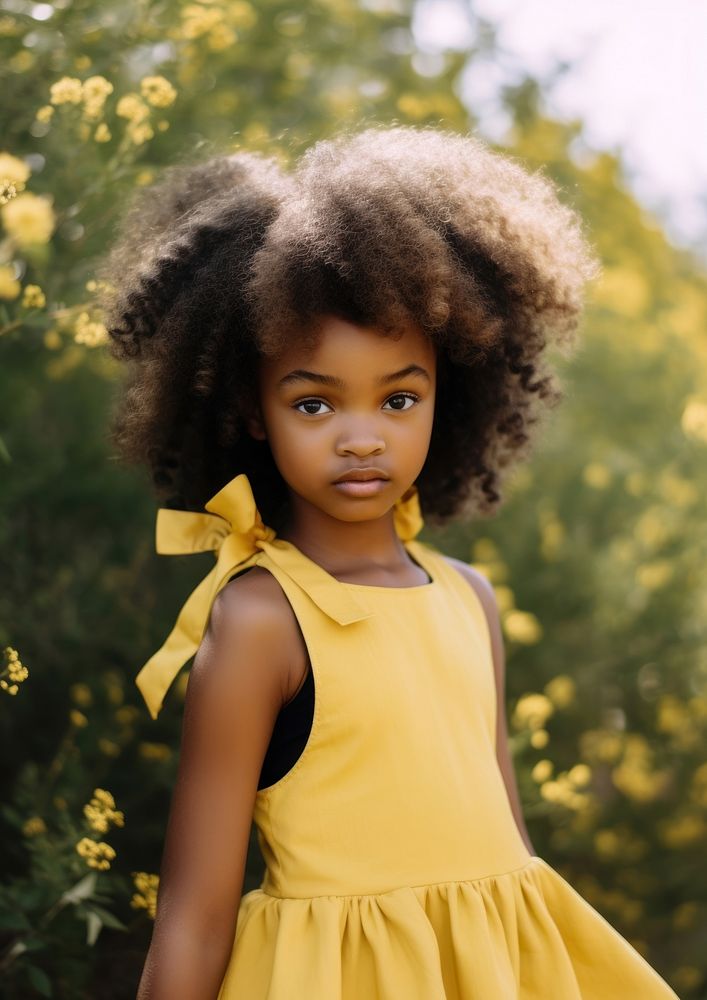 A black girl wearing yellow dress and a pink bow hair clip in the yellow flowers garden portrait photography child. AI…