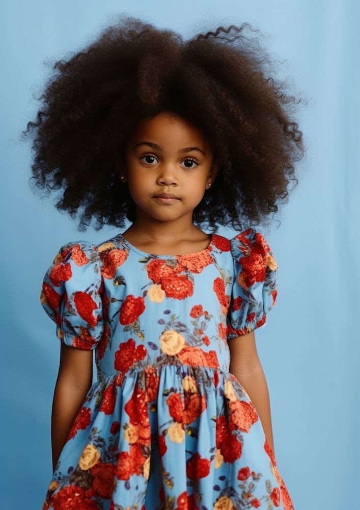 A little black girl wearing cute blue dress with red flowers pattern photography portrait sleeve. AI generated Image by…