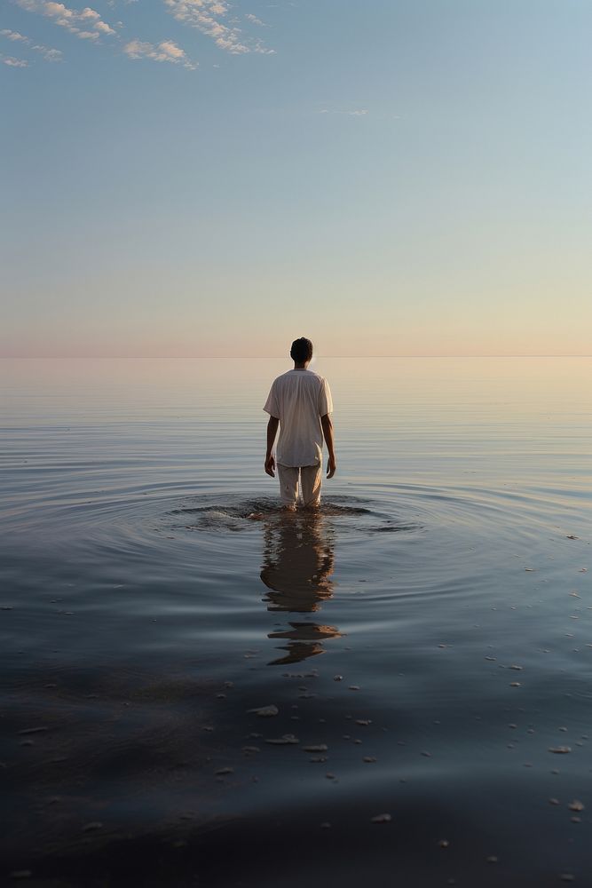 A person walking in the lake sea reflection standing. AI generated Image by rawpixel.